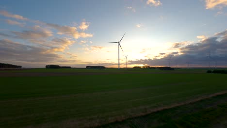 FPV-Drohne-Fliegt-Auf-Einer-Wiese-Mit-Windkraftanlagen
