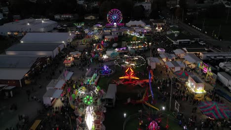 Above-Neon-Lights-of-West-Virginia-Amusement-Park,-funfair-in-USA-by-drone