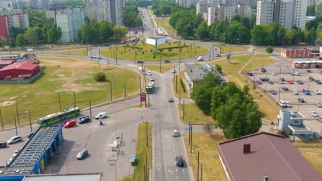 City-traffic-and-roundabout-with-old-apartment-buildings-in-background,-aerial-view