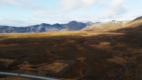 Aerial-of-beautiful-Icelandic-countryside-with-large-mountains-in-the-distance-on-a-sunny-day