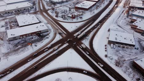 Drone-view-of-a-snow-covered,-very-busy-intersection-in-Calgary-during-winter