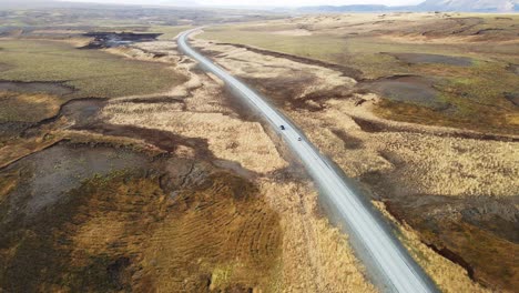 Drone-following-cars-driving-over-a-long-road-in-rural-Iceland