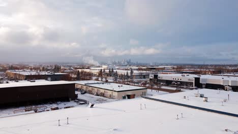 Fliegen-Sie-An-Einem-Eiskalten-Wintermorgen-über-Industrielagerhallen-In-Richtung-Innenstadt-Von-Calgary
