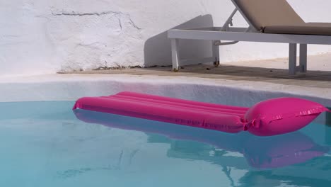 Lifesaver-floater-floating-on-a-calm-swimming-pool-behind-a-deckchair