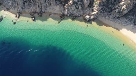 Clear-turquoise-waters-transform-into-deep-blue-at-sea,-Cabo-San-Lucas