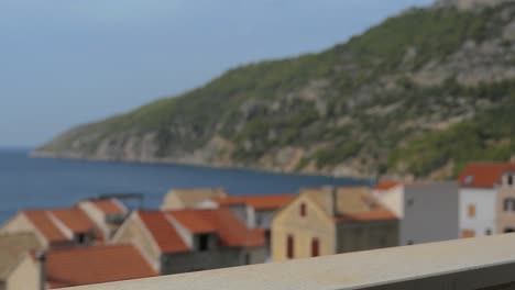 Enjoying-white-wine-on-terrace-with-Mediterranean-sea,-mountain-and-town-view