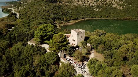 Drone-view-of-Butrint-Archeological-site,-Albania,-Europe-Mass-of-tourists-visiting-the-castle-museum