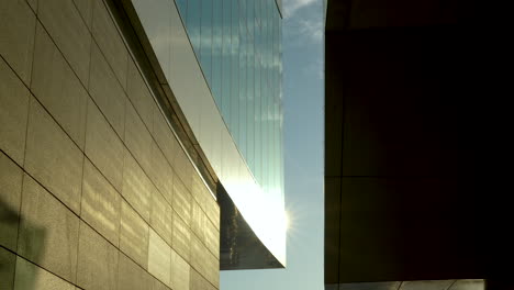 Sonnenlicht-Scheint-Zwischen-Modernen-Gebäuden-Mit-Reflektierenden-Glas--Und-Steinwänden