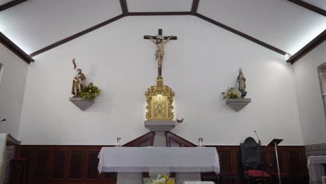 Crucifix-centerpiece-in-church-with-surrounding-statues,-Altar