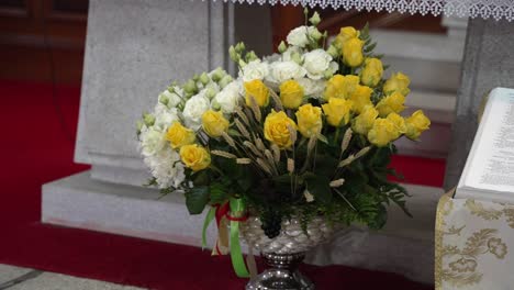 Blumenarrangement-Am-Kirchenaltar-Mit-Offenem-Buch