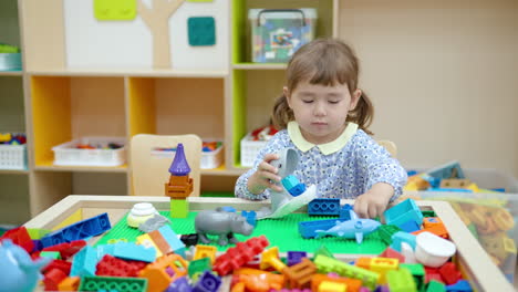 Little-girl-plays-with-building-Lego-blocks-or-bricks