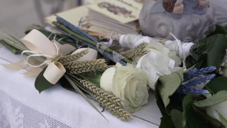 Elegante-Tischdekoration-Mit-Blumen,-Buch-Und-Engelsfigur