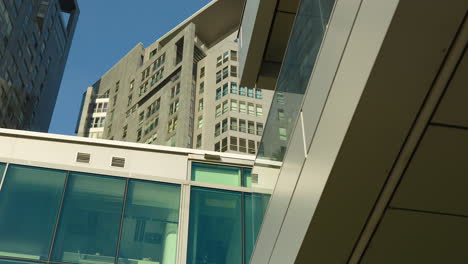 Moderne-Stadtarchitektur-Mit-Eleganten-Glasfassaden-Und-Hoch-Aufragenden-Wohngebäuden-Vor-Klarem-Himmel