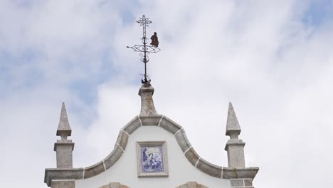 Church-pinnacle-with-weather-vane-and-religious-tile-art