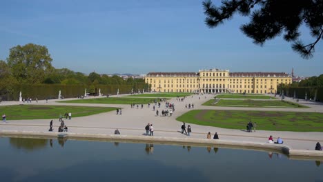Tourists-at-the-Schlosspark-of-Schönbrunn-Palace,-Vienna-on-a-sunny-autumn-morning,-Vienna,-Austria---October-2023