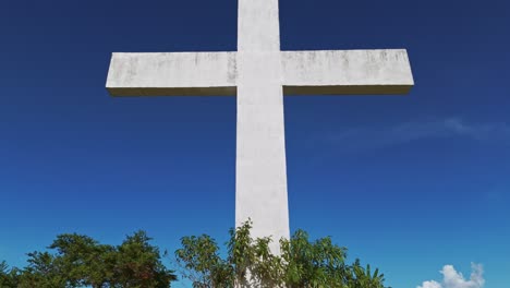 Dolly-pan-up-close-up-of-a-white-christian-cross-in-a-Cemetery-against-a-blue-skies-in-the-philippines