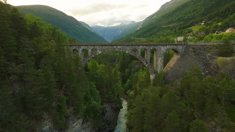 El-Río-Rauma-Fluye-Bajo-El-Puente-Ferroviario-De-Piedra-Kylling-Bru,-Verma,-Noruega