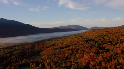 Panoramic-aerial-view-of-fog-streaming-across-valley-in-New-England-at-golden-hour