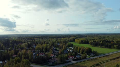 Panoramic-drone-shot-of-the-rural-town-of-Kerava,-a-roadside-village-in-southern-Finland,-sun-hidden-in-the-clouds