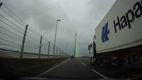 POV-dash-cam-driving-towards-Mersey-gateway-bridge-in-cloudy-overcast-morning-commute-traffic