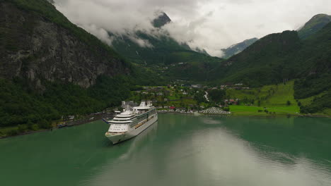 Cruise-vessel-docked-at-popular-tourist-town-in-scenic-Geiranger-fjord