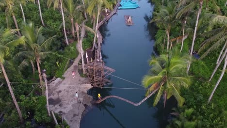 Locals-at-Dive-board-and-Bent-coconut-palm-leaning-on-Maasin-river-of-Siargao