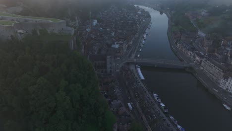 Vista-Por-Drones-De-La-Ciudad-De-Dinant-En-Bélgica-Durante-El-Amanecer-Brumoso,-Aéreo