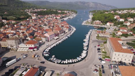 Aerial:-Stari-Grad-marina,-Hvar-Island,-Croatia:-boats-lining-turquoise-bay-amid-historic-architecture
