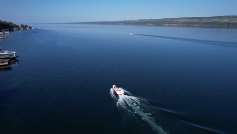 Aerial-view-from-drone-following-a-ski-boat-on-Seneca-Lake-in-the-Finger-Lakes,-NY