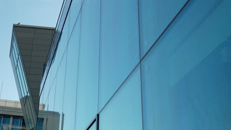 Vorbei-An-Einem-Glänzenden-Bläulichen-Glasgebäude,-Moderner-Architektur