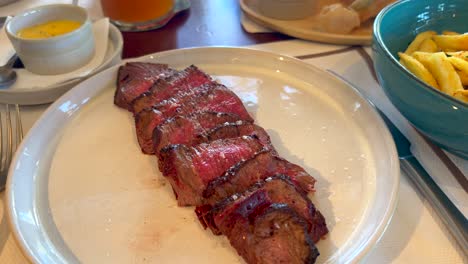 Tasty-beef-filet-steak-with-french-fries-at-Bibo-Beach-House-Tarifa-restaurant,-tapas-of-Dani-Garcia-in-Spain,-4K-shot