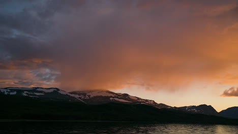 Timelapse-of-storm-clouds-building-over-snowy-mountain-at-sunset