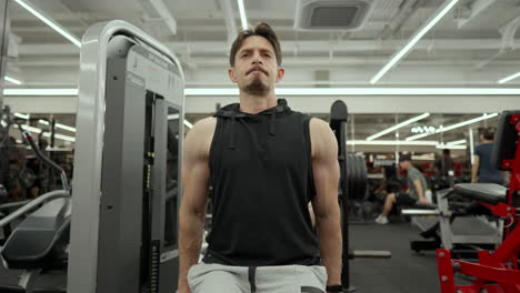 Muscular-Senior-Man-with-Beard-Train-Lower-Chest-in-Dips-Machine---low-angle