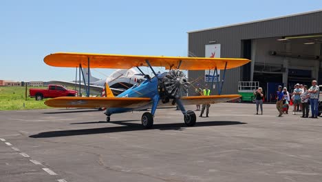 Boeing-Stearman-Model-75-vintage-world-war-II-training-aircraft-taxiing-forward-in-front-of-a-hanger-at-an-airshow-at-the-Centennial-Airport-in-Colorado