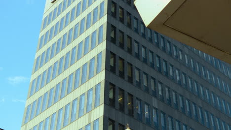 Ein-Modernes-Bürogebäude-Mit-Glasfenstern-Vor-Einem-Klaren-Blauen-Himmel