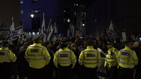 Metropolitan-police-officers-stand-in-line-and-form-a-cordon-during-a-pro-Israel-protest-outside-the-British-Broadcasting-Corporation-offices-at-night