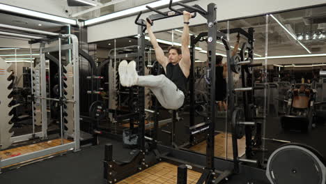 Sporty-Australian-sportsman-doing-hanging-leg-raises-in-gym