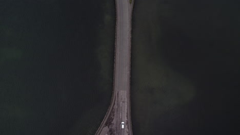 Car-crossing-Lagoa-das-Sete-Cidades-bridge,-São-Miguel-island,-Azores---Aerial-top-view