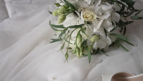 Eleganter-Brautstrauß-Auf-Weißem-Hochzeitskleid-Hintergrund