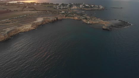 Tilt-up-shot-of-rocky-coast-near-Punta-della-mola-Sicily-Italy,-aerial
