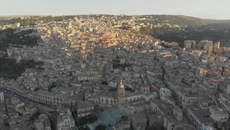 Wide-view-of-famous-Modica-city-at-Sicily-during-sunrise,-aerial