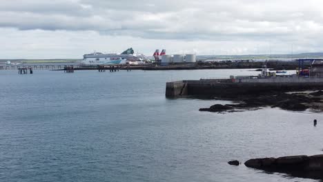 Aerial-view-across-Holyhead-harbour-with-police-boat-and-Irish-ferry-ship-in-Welsh-port-terminal,-Reverse-shot
