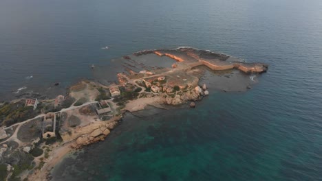 Side-panning-shot-of-Punta-della-Mola-ruins-at-Sicily-Italy,-aerial