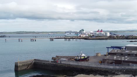 Aerial-dolly-view-across-Holyhead-harbour-with-police-boat-and-Irish-ferry-ship-in-Welsh-port-terminal