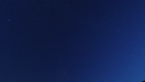 Time-lapse-looking-up-at-clouds-passing-twinkling-stars-in-the-clear-night-sky