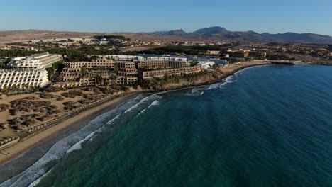 Costa-Calma,-Fuerteventura:-aerial-view-traveling-in-towards-the-coast-and-where-you-can-see-the-resorts-of-the-tourist-area
