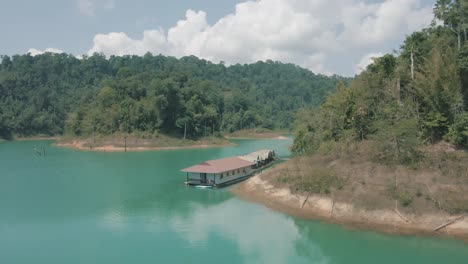 Imágenes-Increíbles-De-Drones-De-Personas-Nadando-Junto-A-Bungalows-Flotantes-En-El-Parque-Nacional-De-Khao-Sok,-Tailandia