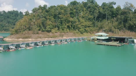 Epische-Drohnenaufnahmen,-Die-Eine-Gruppe-Von-Menschen-Zeigen,-Die-An-Überwasserbungalows-Im-Nationalpark-Khao-Sok-In-Thailand-Schwimmen