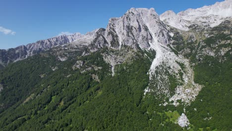 Epische-Alpine-Majestät:-Hoch-Aufragender-Berg-Mit-Schroffen-Felsgipfeln-Und-üppig-Grünen-Bewaldeten-Hängen,-Ein-Majestätisches-Naturschauspiel
