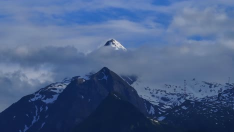 Über-Den-Wolken,-Der-Gipfel-Eines-Majestätischen-Berges,-Bedeckt-Mit-Schnee-Und-Eis